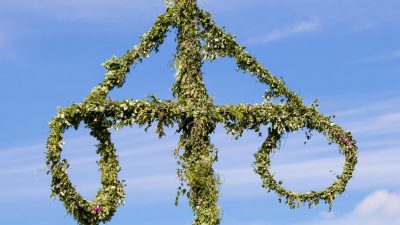 En midsommarstång mot en blå himmel.